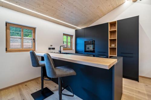 a kitchen with a blue island in a house at Chalet Lanthalerhof in San Martino