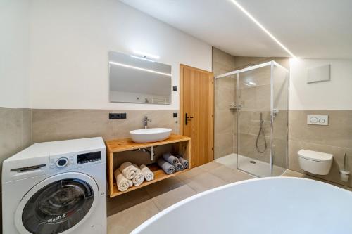 a bathroom with a washing machine and a sink at Chalet Lanthalerhof in San Martino