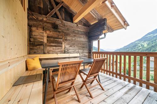 a table and chairs on the deck of a cabin at Chalet Lanthalerhof in San Martino