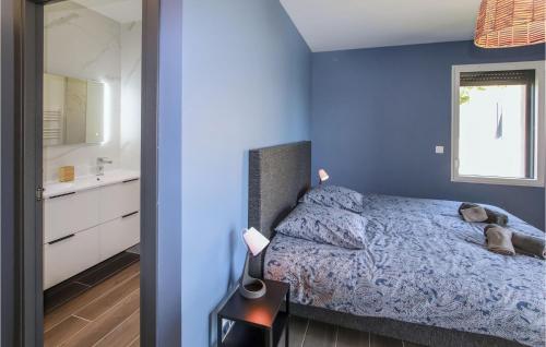 een blauwe slaapkamer met een bed met een teddybeer erop bij 4 Bedroom Stunning Home In Clon Dandran in Cléon-dʼAndran