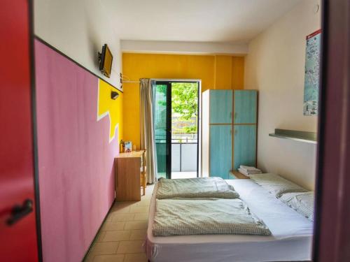 2 camas en una habitación de color amarillo y azul en Hotel Elba, en Rímini