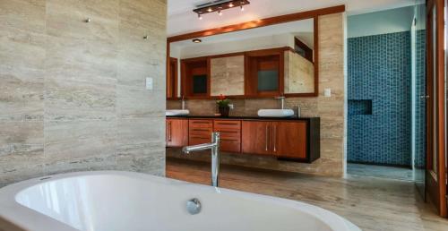 uma casa de banho com uma banheira, um lavatório e um espelho. em Sunny Vacation Villa No 60 em San Rafael del Yuma
