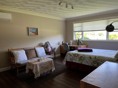 1 dormitorio con cama, silla y escritorio en Xinglin house, en Charlottetown
