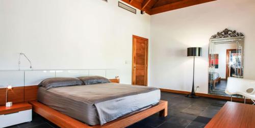 um quarto com uma cama, uma mesa e um espelho em Sunny Vacation Villa No 60 em San Rafael del Yuma