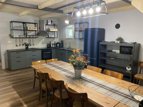 a kitchen with a large wooden table and chairs at Chata Pekný les in Horné Hámre