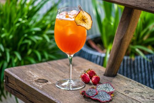 a drink sitting on a wooden table next to some strawberries at Mandilla in Köveskál