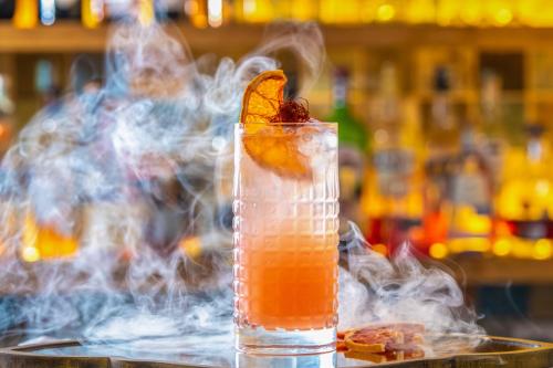 a drink with an orange slice and smoke at Mandilla in Köveskál