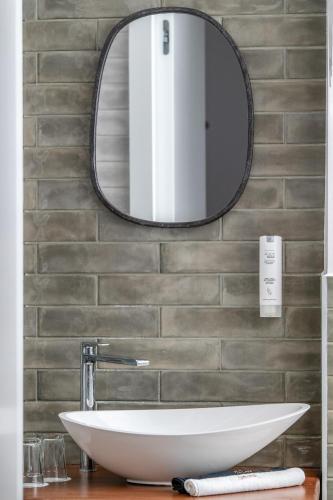 a bathroom with a sink and a mirror on a wall at Mandilla in Köveskál