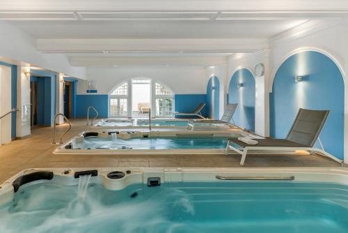 een groot zwembad in een kamer met blauwe muren bij The Headland Hotel & Spa in Torquay