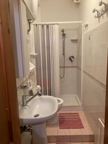 a white bathroom with a sink and a shower at Bed & Breakfast 5 Di Spade in Gioiosa Marea