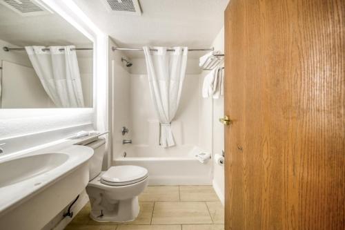 a bathroom with a toilet and a tub and a sink at Baymont by Wyndham Orlando-International Dr-Universal Blvd in Orlando