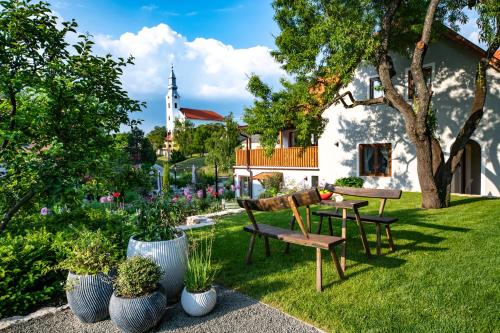 a garden with benches and potted plants and a church at Mandilla in Köveskál