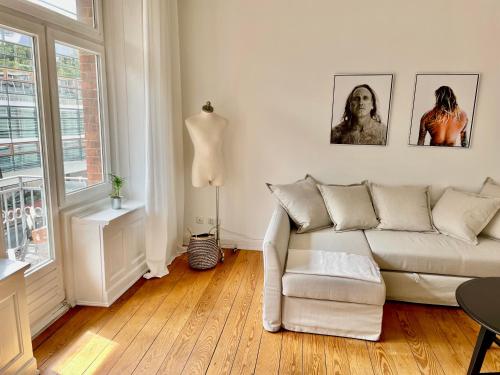 ein Wohnzimmer mit einem weißen Sofa und einem Fenster in der Unterkunft Elbperle! Zentrales Apartment an der Elbe in Hamburg