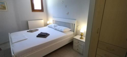1 dormitorio con 1 cama blanca y 2 toallas en Christie's ground floor apartment by the sea, en Kato Gatzea