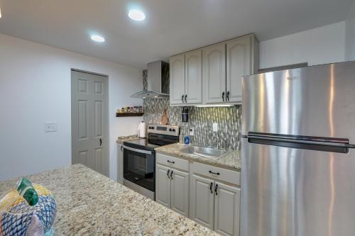 a kitchen with white cabinets and a stainless steel refrigerator at Pet-Friendly Caneadea Retreat with Deck! in Oramel
