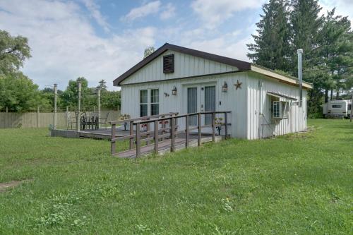 a white building with a deck in the grass at Pet-Friendly Caneadea Retreat with Deck! in Oramel