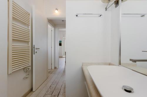 uma casa de banho branca com uma banheira e um corredor em Cagliari - Modern Apartment with Terrace! em Cagliari