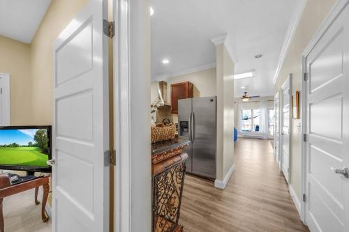 a hallway of a home with a refrigerator and a television at Loft Apt with Balcony in the Heart of Kennett Square in Kennett Square