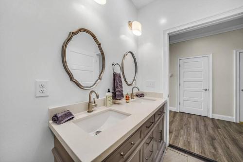 a bathroom with a sink and two mirrors on the wall at Loft Apt with Balcony in the Heart of Kennett Square in Kennett Square