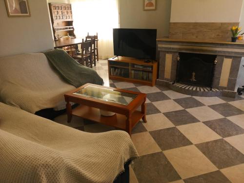 a living room with a tv and a fireplace at Agradable casa con jardín: Casasola in San Cristóbal de Segovia