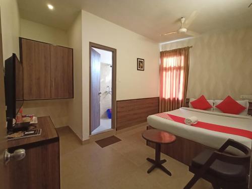HOTEL INDIANA في شيلونغ: غرفة نوم بسرير وكرسي ونافذة