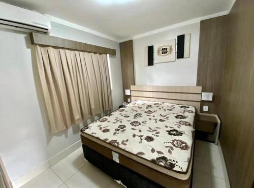 ein Schlafzimmer mit einem Bett in einem Zimmer in der Unterkunft Lacqua Diroma - parque 24H in Caldas Novas