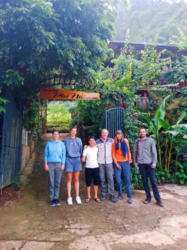 a group of people standing in front of a gate at homestay phô núi suôi giang in Yên Bái