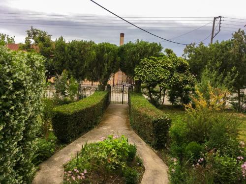 un jardín con una puerta y arbustos en Calda Ospitalita, en Néa Karyá