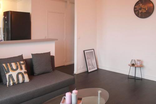 ein Wohnzimmer mit einem Sofa und einem Tisch in der Unterkunft Bright apartment - Romainville in Romainville