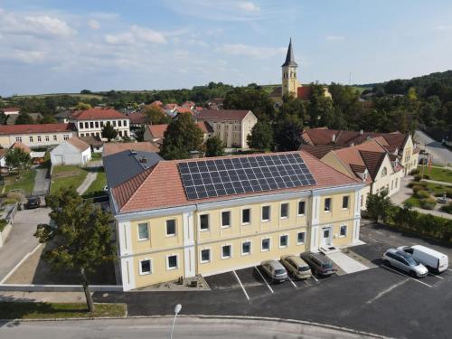 a large yellow building with solar panels on its roof at Weinlandmotel in Ebenthal