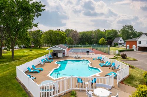 an overhead view of a large swimming pool with chairs and tables at Les Suites de Laviolette, an Ascend Collection Hotel in Trois-Rivières