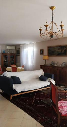 - un lit dans un salon doté d'un lustre dans l'établissement Mare è Monte , jardin méditerranéen et exotique., à Ghisonaccia