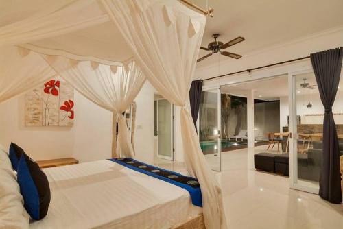 a bedroom with a bed with a ceiling fan at Selog Villa 4 in Seminyak