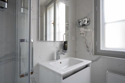 uma casa de banho branca com um lavatório e um espelho em Hotel Barborský dvůr em Kutná Hora