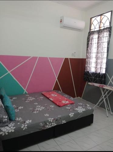 a room with a bed and a chair at Brown Homestay Teluk Kemang Port Dickson in Port Dickson