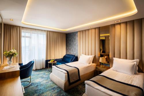 ゴールデン・サンズにあるAdmiral Hotel - Ultra All Inclusive & Private Beachのベッド2台とデスクが備わるホテルルームです。