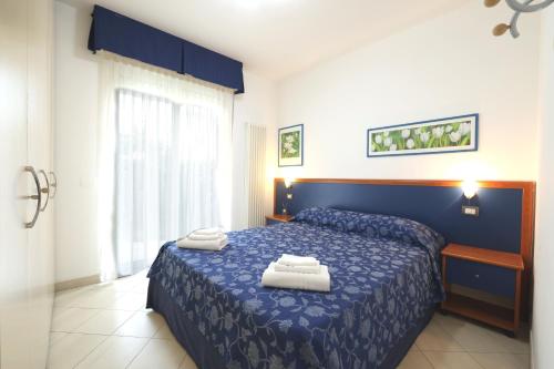 um quarto com uma cama azul com toalhas em We Home - PALESTRINA17 - Riccione sul mare em Riccione
