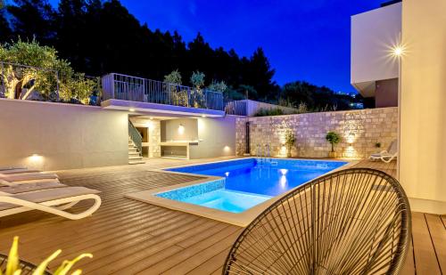 una piscina en medio de una casa en Villa Luxury HERMES - Heated Pool, Jacuzzi, Elevator en Podstrana