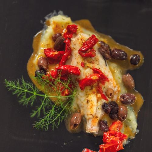 a piece of pizza with beans and vegetables on a table at Il Borgo BagaBaga - Exclusive Country Retreat in Castelsardo