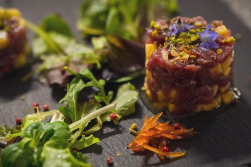 a plate of food with a piece of food with vegetables at Il Borgo BagaBaga - Exclusive Country Retreat in Castelsardo