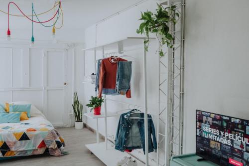 een kamer met een bed en een plank met kleding bij El garage in Esquel