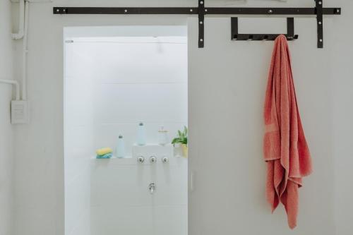 een douchedeur met een rode handdoek erop bij El garage in Esquel