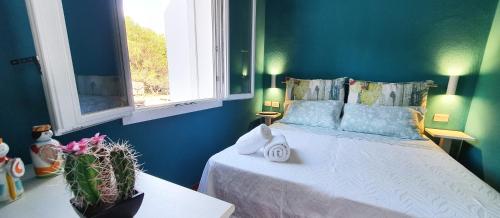 Un dormitorio con una cama con paredes azules y una ventana en TramontanaBeach, en Tracino