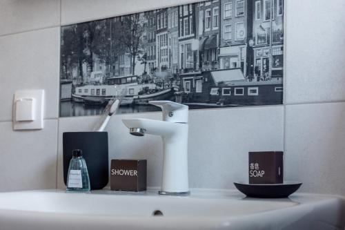 a bathroom sink with a faucet and a picture on the wall at Amazing Condo in Brașov by Valentino - Free Garage Parking in Braşov