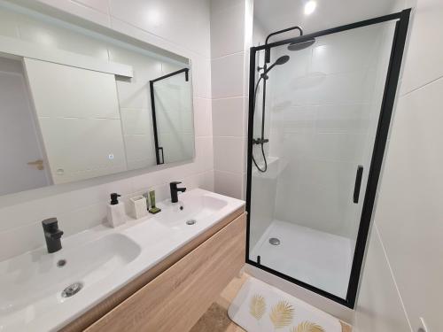 une salle de bain blanche avec une douche et un lavabo dans l'établissement Nîmes arènes - T2 calme climatisé, à Nîmes