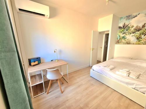 une petite chambre avec un lit et un bureau dans l'établissement Nîmes arènes - T2 calme climatisé, à Nîmes