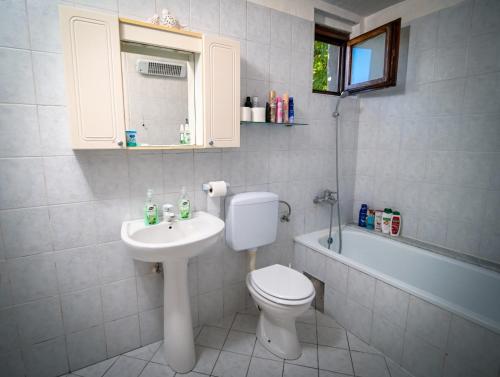 uma casa de banho com um WC, um lavatório e uma banheira em Lalić rooms em Sarajevo