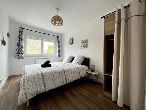 un dormitorio con una cama con un gato negro sentado en ella en Le grand morétain, en Moret-sur-Loing