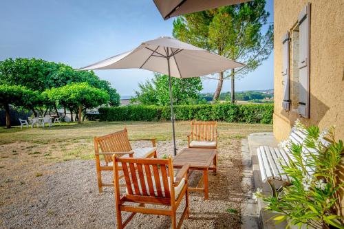 two chairs and a table with an umbrella at A Lantin in Auch