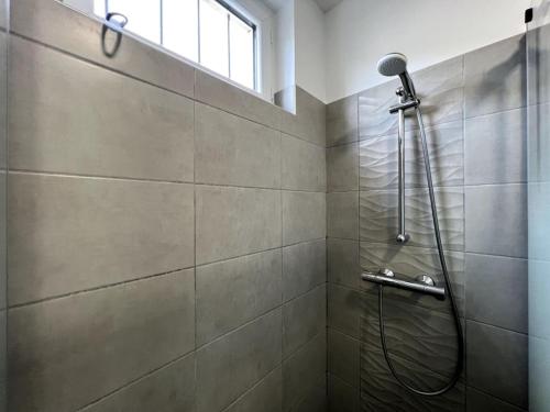 a bathroom with a shower with a shower head at Le grand morétain in Moret-sur-Loing